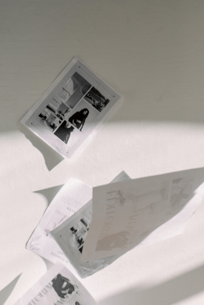 Showit Website for Photographers | High Tide Strategy Full Service Marketing Agency | Black and white photo of floating papers casting shadows on a wall. Each paper shows images of people and buildings, creating a nostalgic atmosphere.