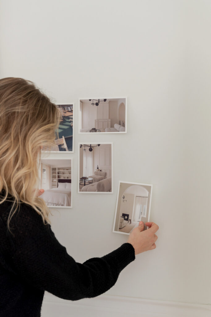 Showit Slideshow Wedding Photography | High Tide Strategy Full Service Marketing Agency | A person with blonde hair arranges photos of minimalist interiors on a white wall. The images depict elegant, neutral-toned rooms, conveying a sense of calm.