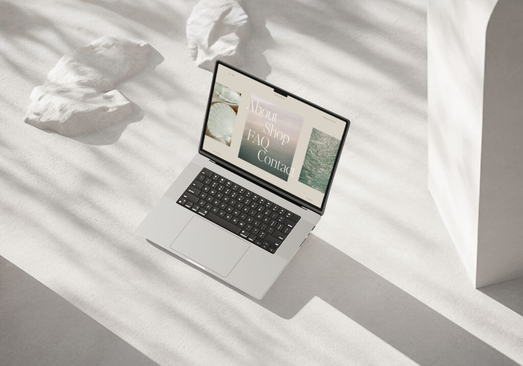 Med Spa Marketing | High Tide Strategy Full Service Marketing Agency | A laptop displaying a webpage with "About, Shop, FAQ, Contact" text, set on a sunlit, textured white surface.