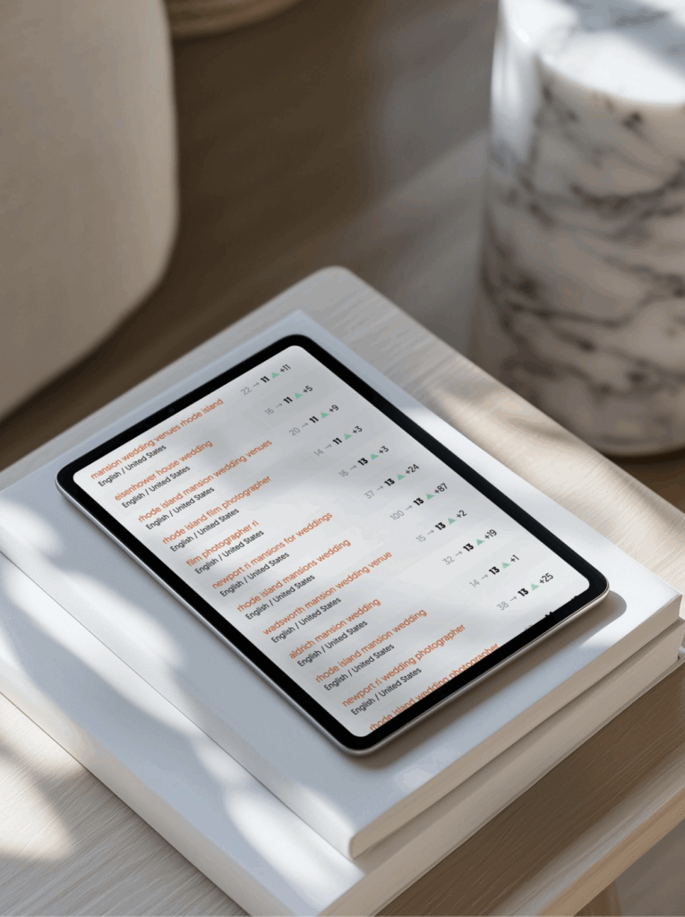 SEO Tips for Photographers | High Tide Strategy Full Service Marketing Agency | A tablet displaying a list with numerical data. It's on a white book, bathed in natural light, with a marble item nearby, creating a serene, focused setting.