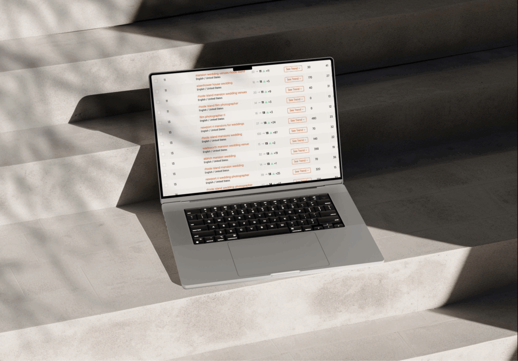 SEO Tips for Photographers | High Tide Strategy Full Service Marketing Agency | A laptop displaying a spreadsheet is set on concrete steps with soft, diagonal shadows. The scene is minimalistic and evokes a sense of calm focus.