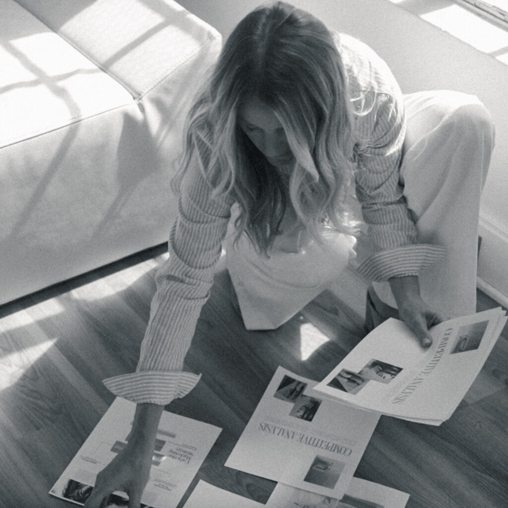Mandy Ford SEO Expert crafts a marketing strategy and brand positioning chart on the floor in a studio. black and white photo