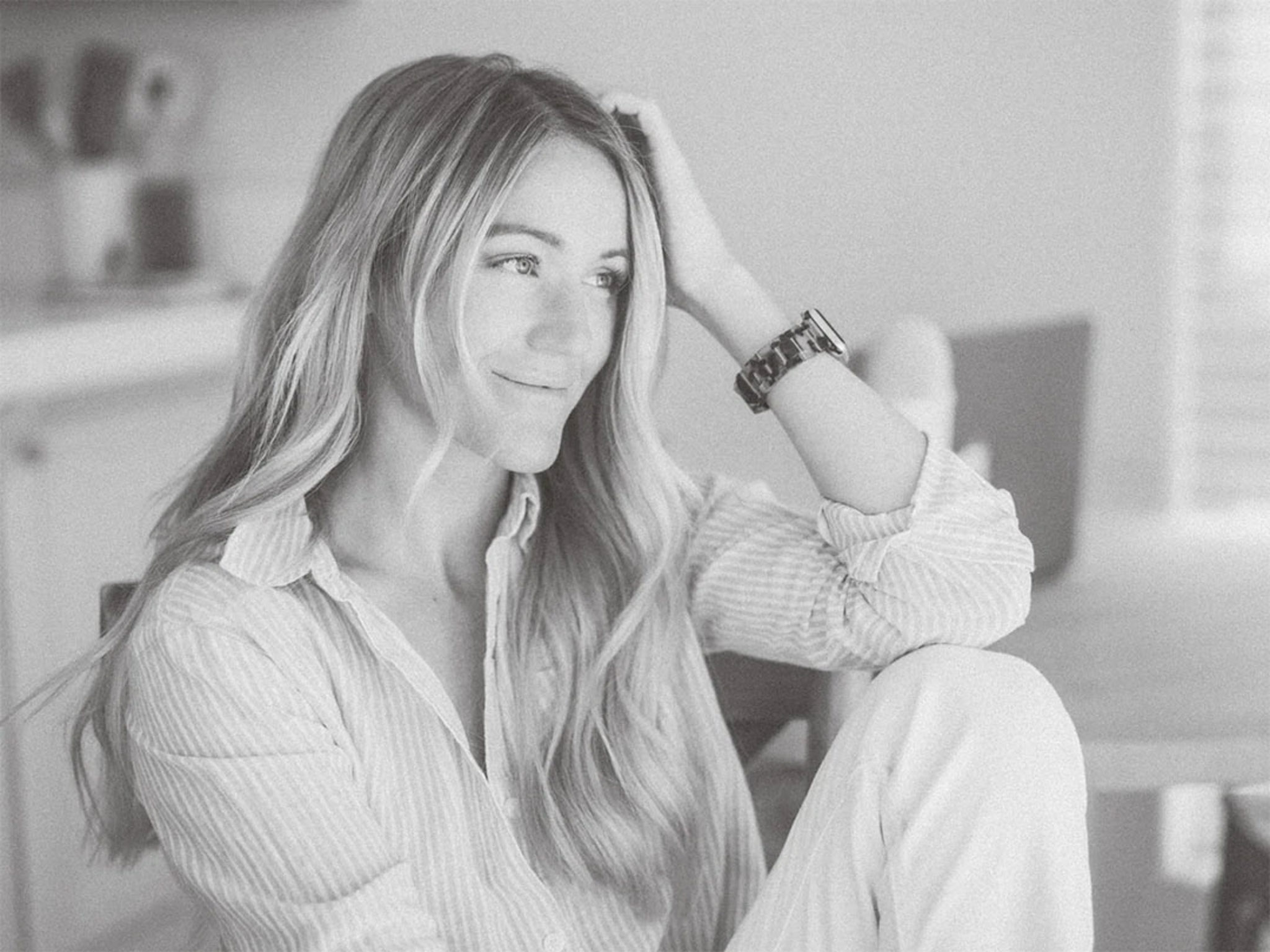 A blonde woman from high tide strategy sits in a room with her head resting on her hand.