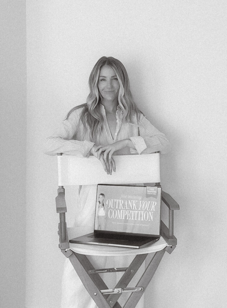 Mandy from High Tide Strategy stands behind a white chair with an open laptop showing a curated website optimized for brand visibility.